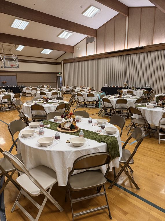 The cultural hall set with round tables, fall centerpieces, and green runners