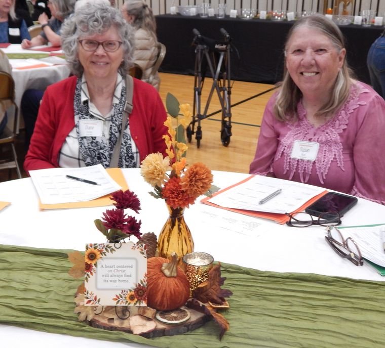 Two sisters smiling together at their table