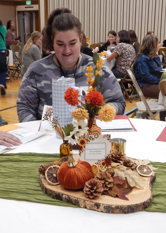 A sister reading her conference folder at a decorated table