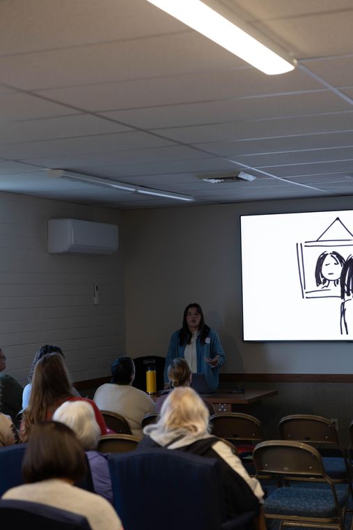 Sisters listening to a presentation in a darkened classroom